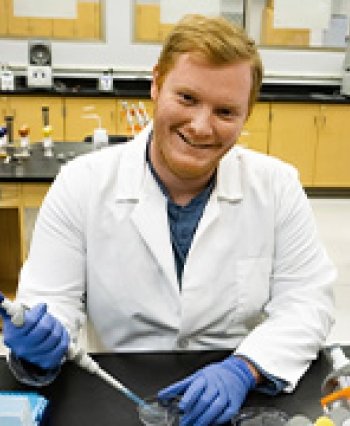 91Ӱ Transfer Student Jarrett Stites holds a pipet in biology lab.