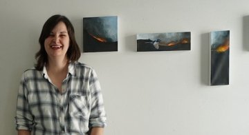 91Ӱ Faculty Member Katherine Eagle Poses with her paintings